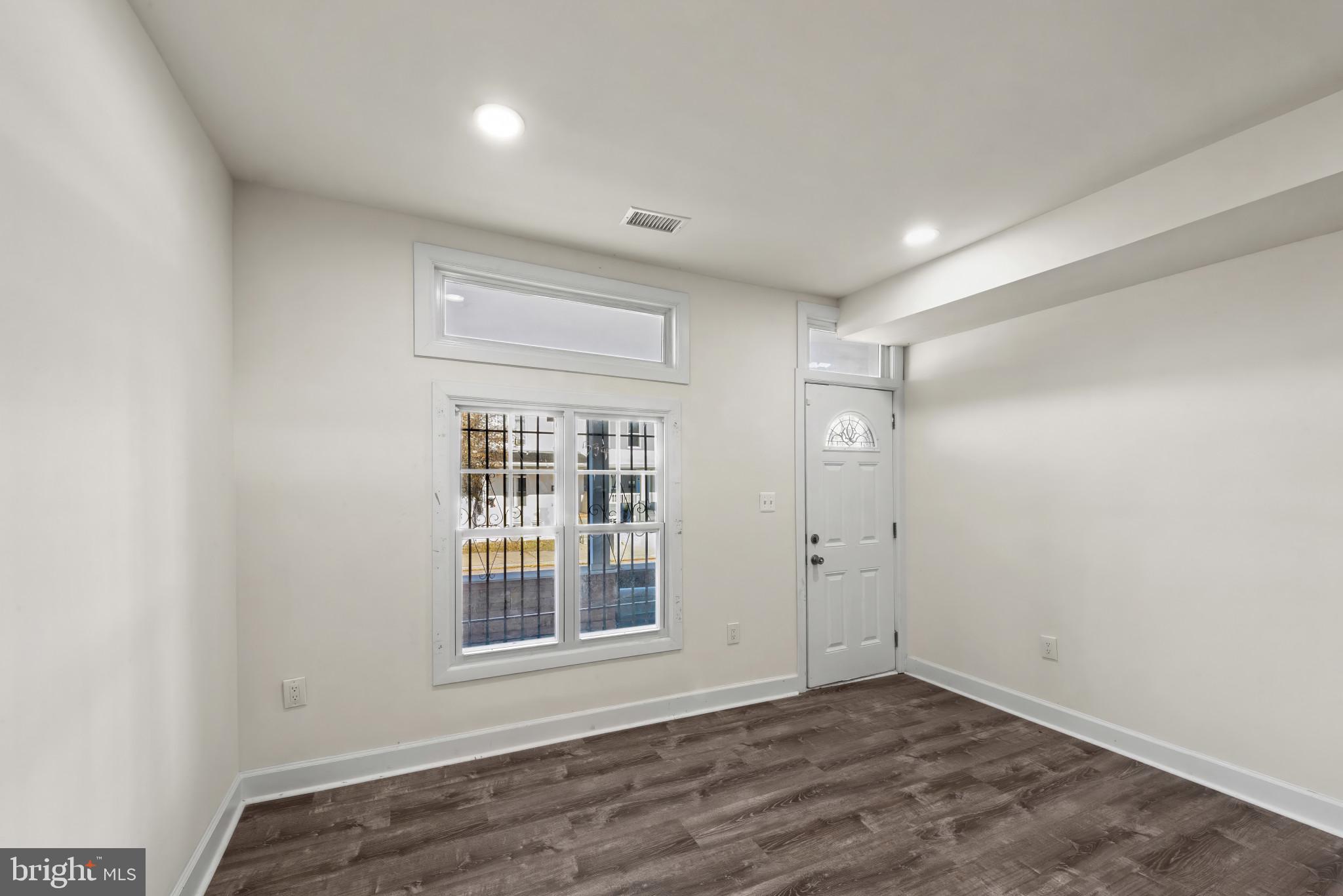 2419 Baker Street Baltimore, MD 21216 - Photo 4 of 40 a view of an empty room with wooden floor and a window