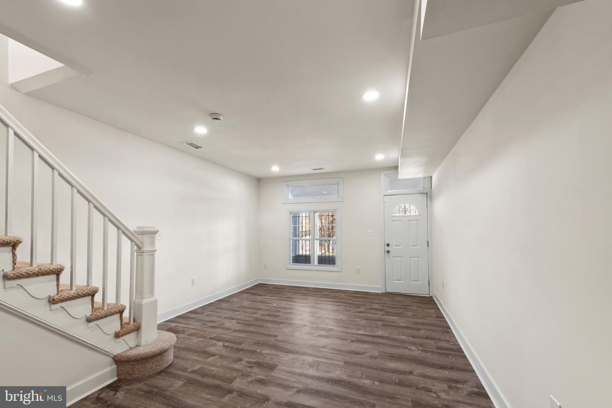 2419 Baker Street Baltimore, MD 21216 - Photo 6 of 40 a view of an empty room with wooden floor and entryway