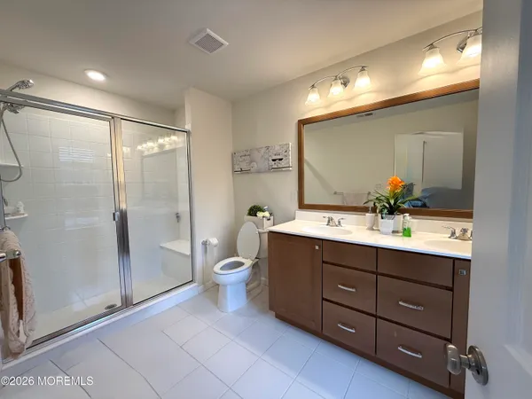 a bathroom with a double vanity sink toilet and shower