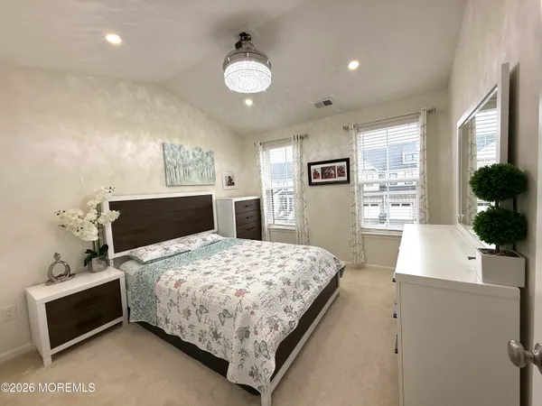 a bedroom with a large bed and a flat tv screen on dresser