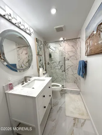 a bathroom with a sink a toilet and shower