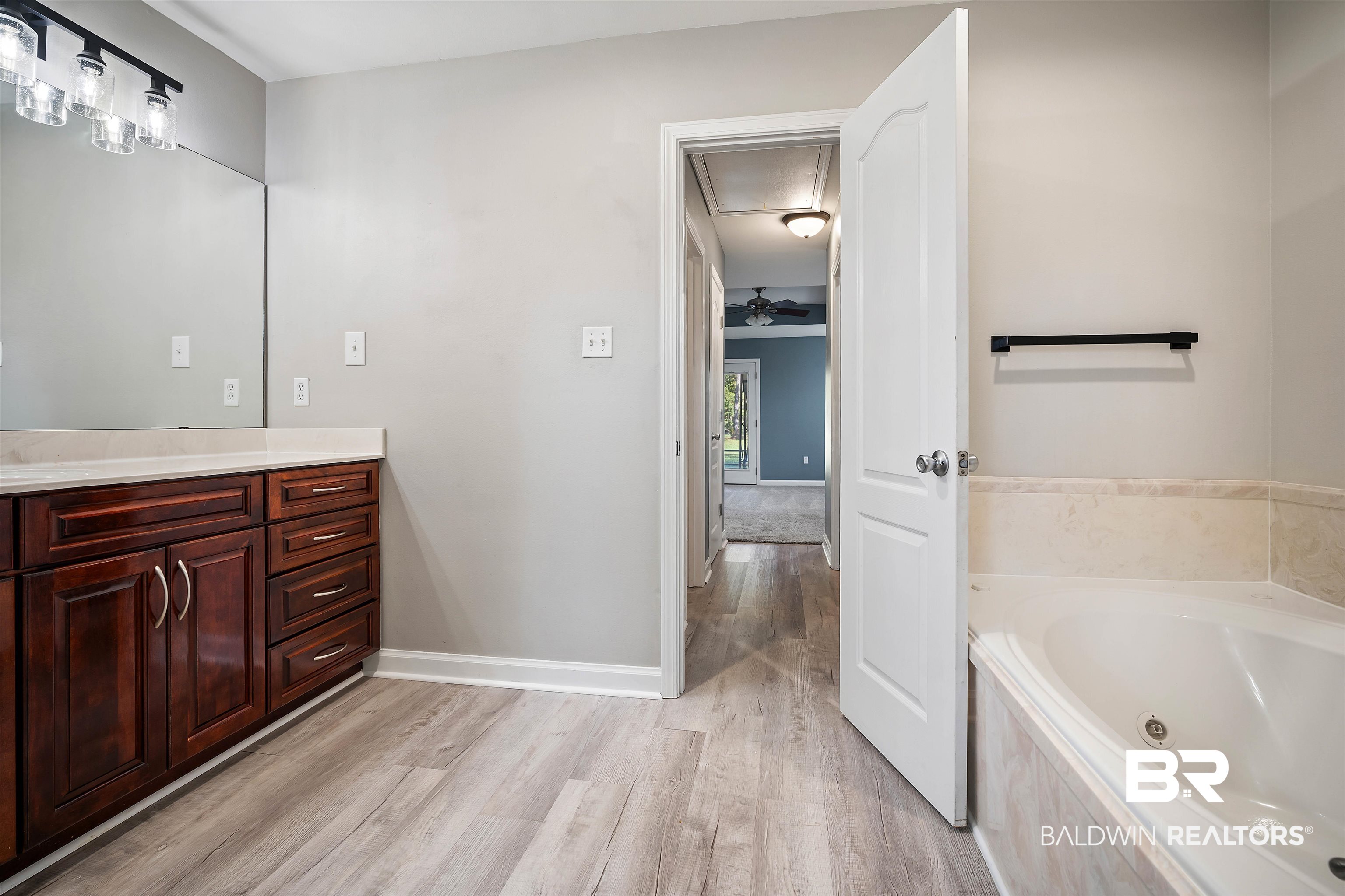 3010 Drag Strip Lane Coden, AL 36523 - Photo 19 of 44 Bathroom with hardwood / wood-style floors, vanity, ceiling fan, and a relaxing tiled tub