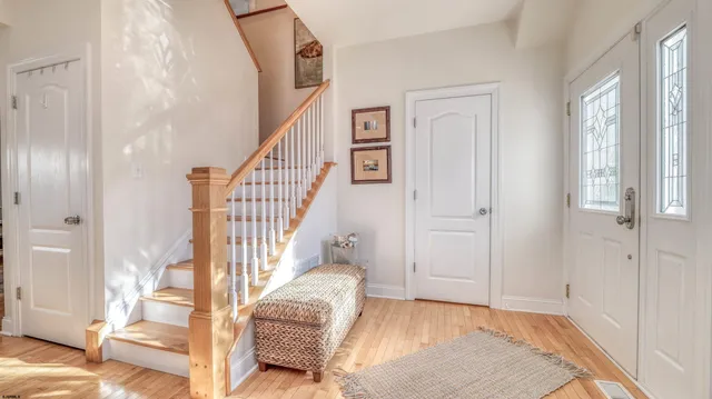 a view of entryway bedroom and hall with wooden floor