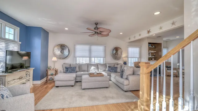 a living room with furniture a flat screen tv and a large window