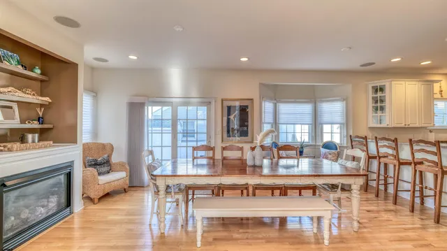 a view of a a dining room with furniture window and wooden floor