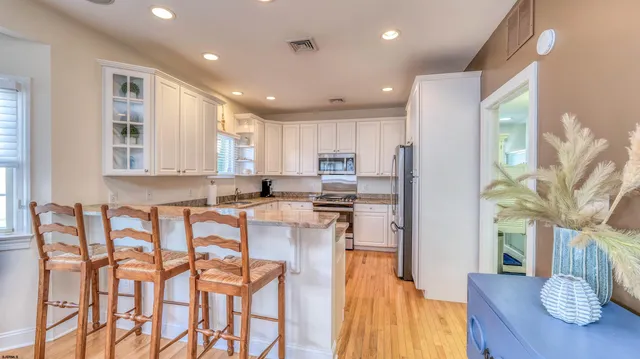 a kitchen with stainless steel appliances granite countertop a table and chairs in it