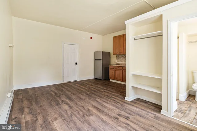 a view of empty room with wooden floor and window