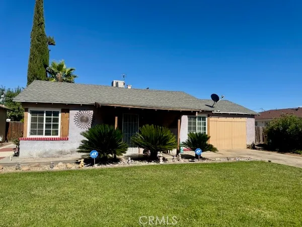 a view of house with yard and outdoor seating
