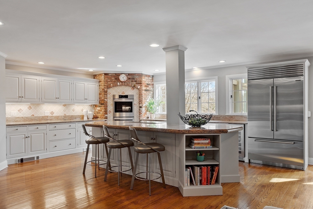 336 Lexington Road Concord, MA 01742 - Photo 21 of 41 a kitchen with stainless steel appliances granite countertop a table chairs sink refrigerator and cabinets