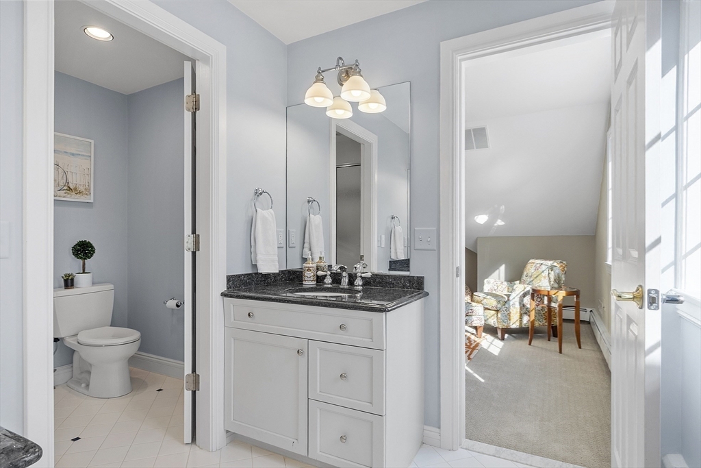 336 Lexington Road Concord, MA 01742 - Photo 28 of 41 a en suite bathroom with a granite countertop toilet a mirror and a shower