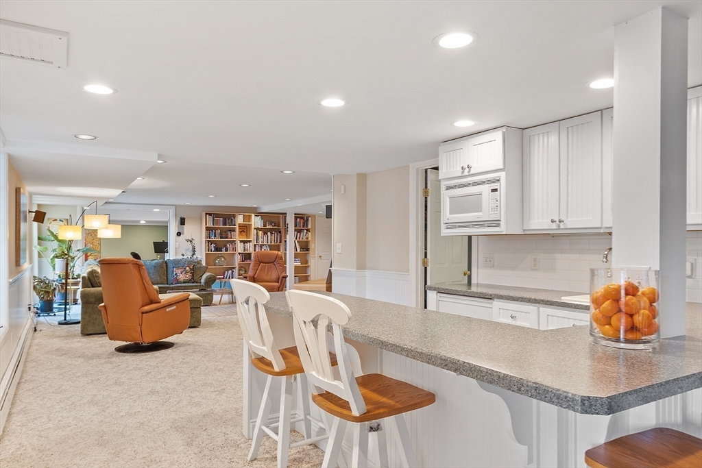 336 Lexington Road Concord, MA 01742 - Photo 37 of 41 a kitchen with stainless steel appliances granite countertop a table and chairs in it