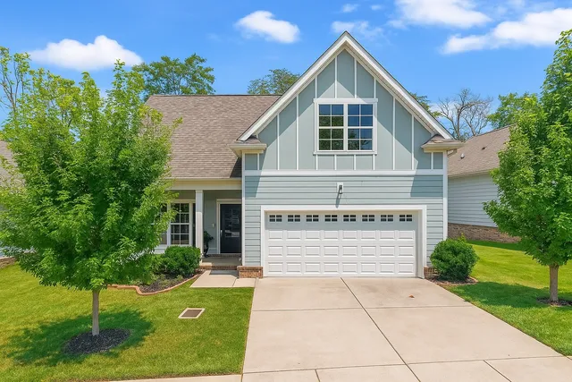 a view of a house with a yard and potted plants