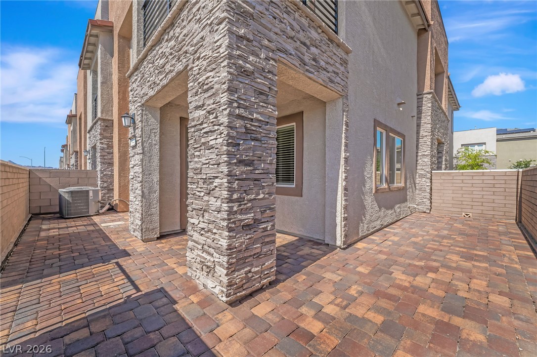 894 Cadence View Way Henderson, NV 89011 - Photo 2 of 23 A private outdoor space with a paver patio and modern stacked stone accents awaits.