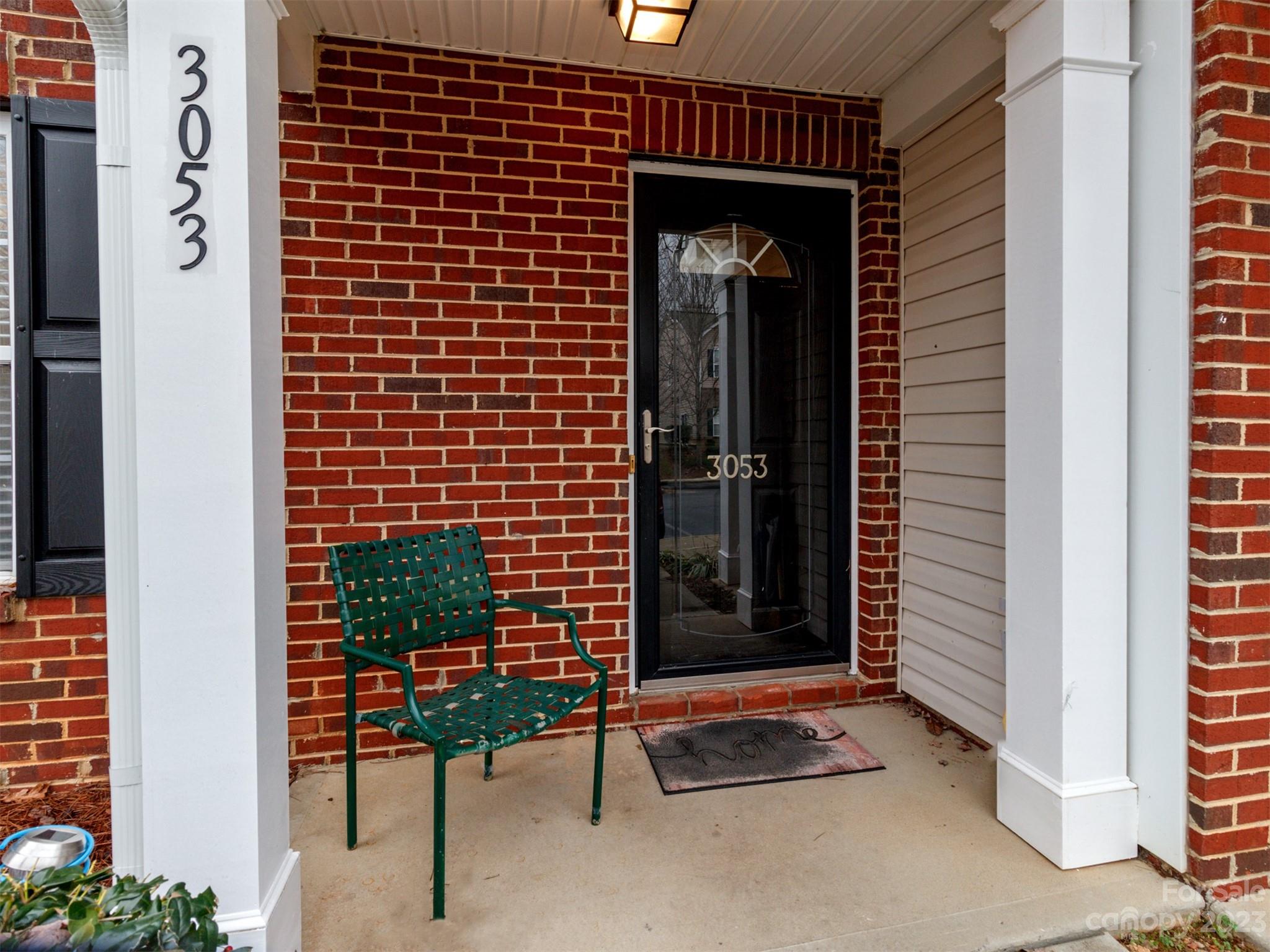 3053 Summerfield Ridge Lane Matthews, NC 28105 - Photo 5 of 37 a brick building with a bench in front of door