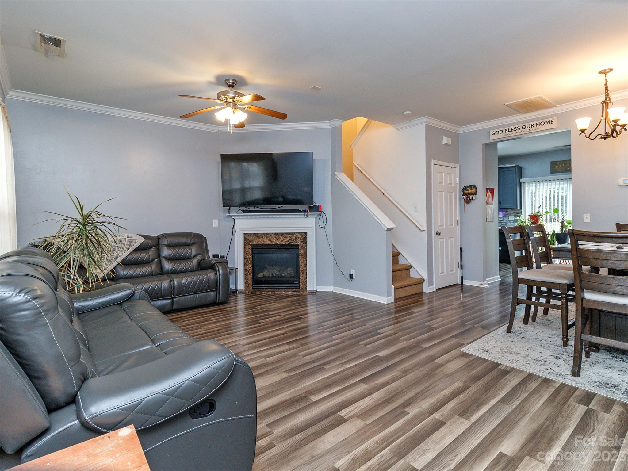 3053 Summerfield Ridge Lane Matthews, NC 28105 - Photo 7 of 37 a living room with furniture a fireplace and a flat screen tv