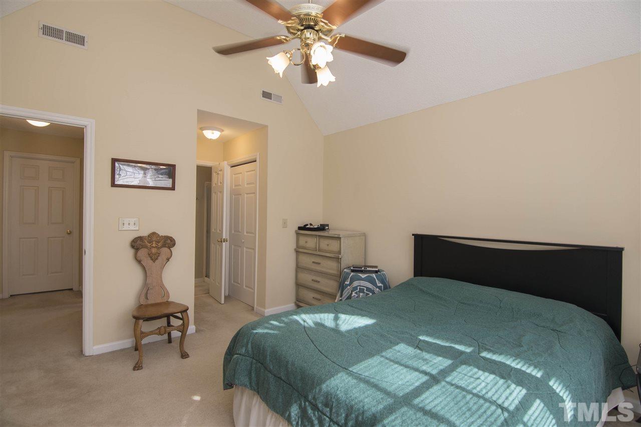 4416 Emmit Drive Raleigh, NC 27604 - Photo 13 of 28 a bedroom with a bed and a chandelier