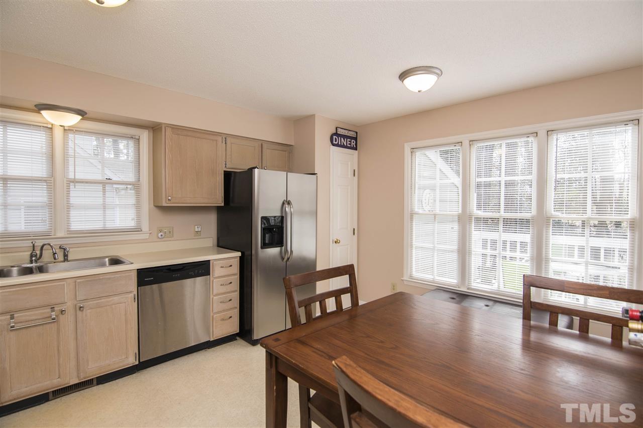 4416 Emmit Drive Raleigh, NC 27604 - Photo 10 of 28 a kitchen with stainless steel appliances granite countertop a stove a refrigerator a sink a dining table and chairs