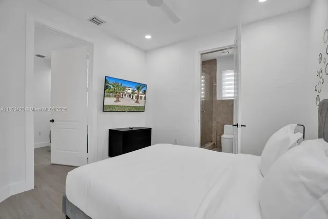 a bed sitting in a bedroom next to a window and a potted plant