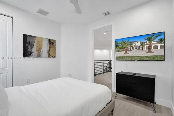 a bed sitting in a bedroom next to a window and a potted plant