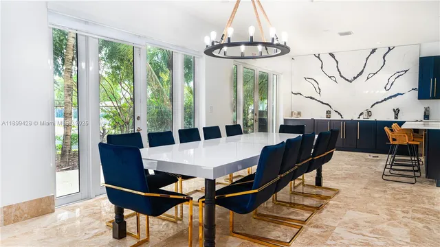 a kitchen with stainless steel appliances kitchen island granite countertop a table chairs and a wooden cabinets