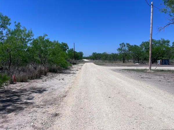 a view of a dirt road with a building in the background