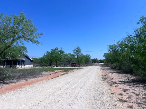 a view of a road with a house in the background