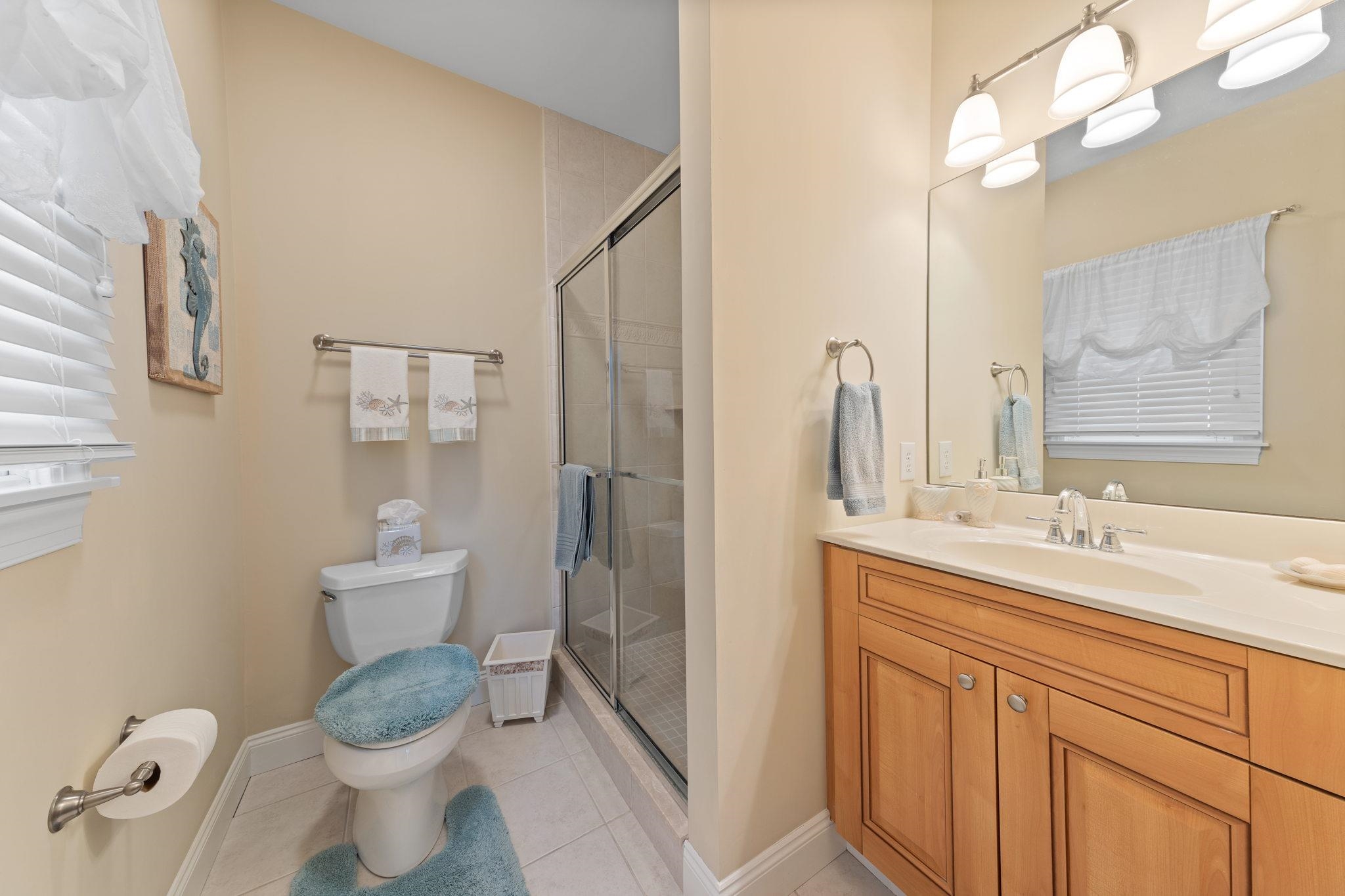 244 23rd Street Avalon, NJ 08202 - Photo 17 of 21 a bathroom with a granite countertop toilet sink and mirror