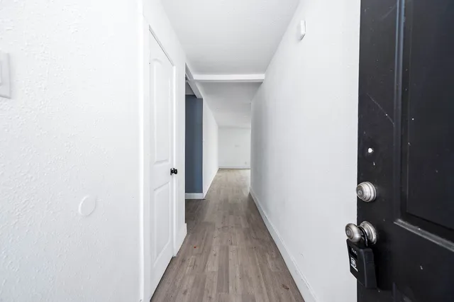 a view of a hallway with wooden floor