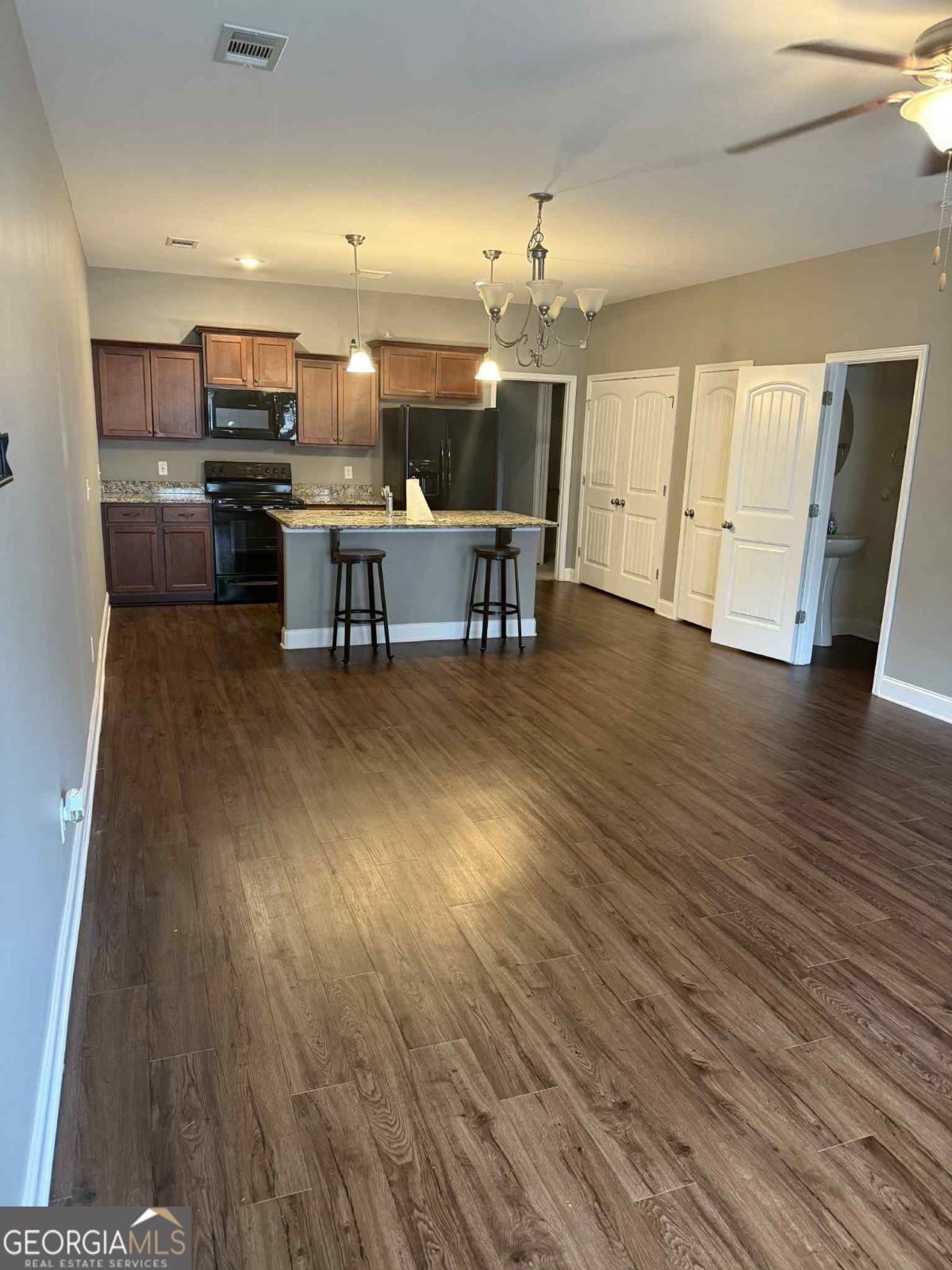 11330 White Bluff Road, Unit 34 Savannah, GA 31419 - Photo 2 of 4 an open kitchen with wooden floor and stainless steel appliances