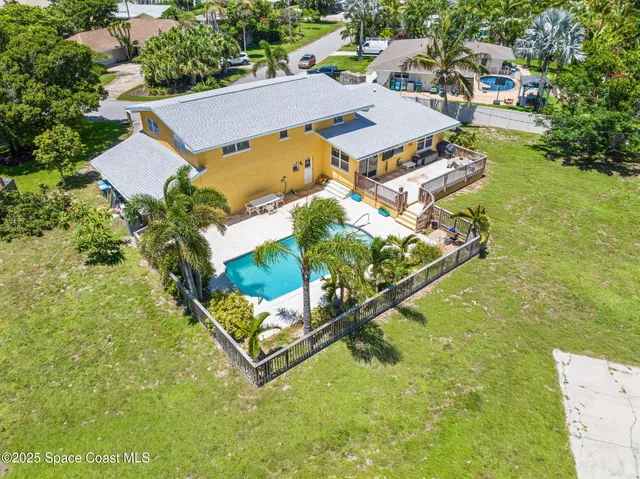 an aerial view of residential house with outdoor space and trees all around
