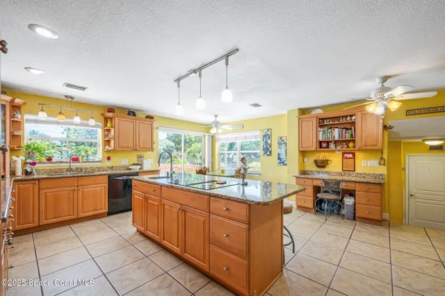 a large kitchen with kitchen island granite countertop a large counter top space appliances and cabinets