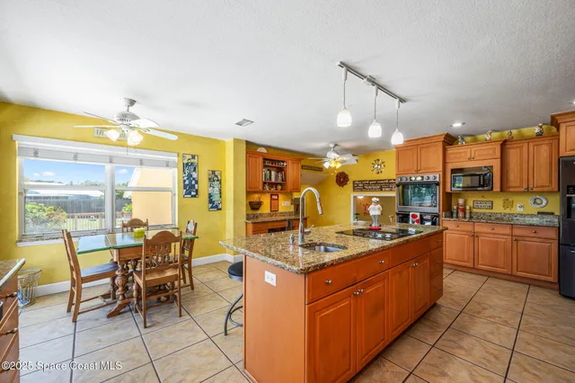 a kitchen with stainless steel appliances granite countertop table chairs and a stove