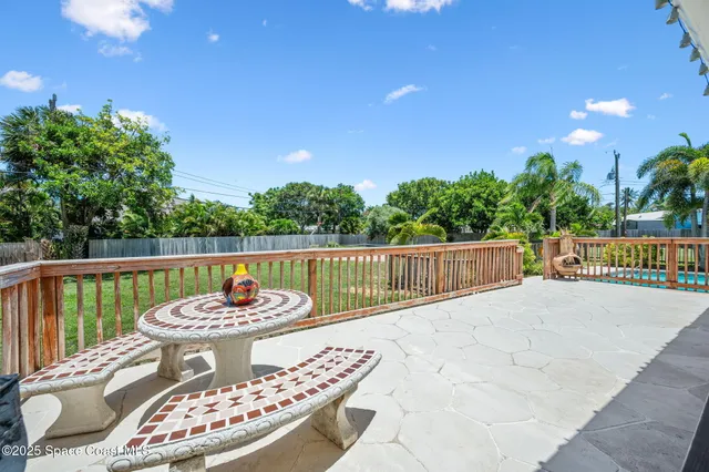 a view of a patio with dining table and chairs under an umbrella