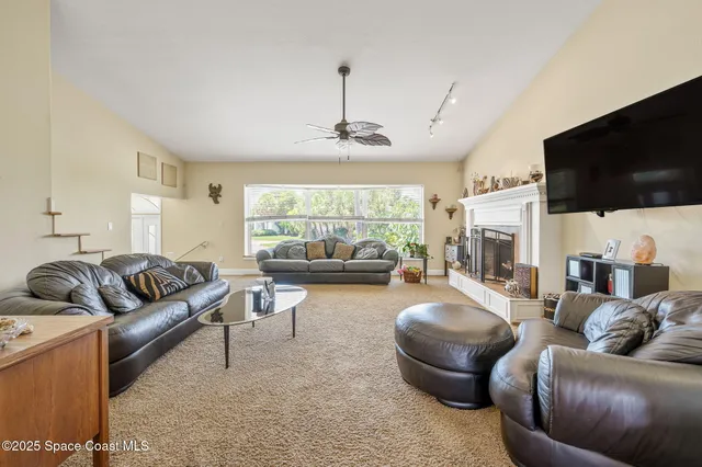 a living room with furniture a flat screen tv and a large window