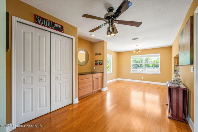 a view of a livingroom with wooden floor and a ceiling fan