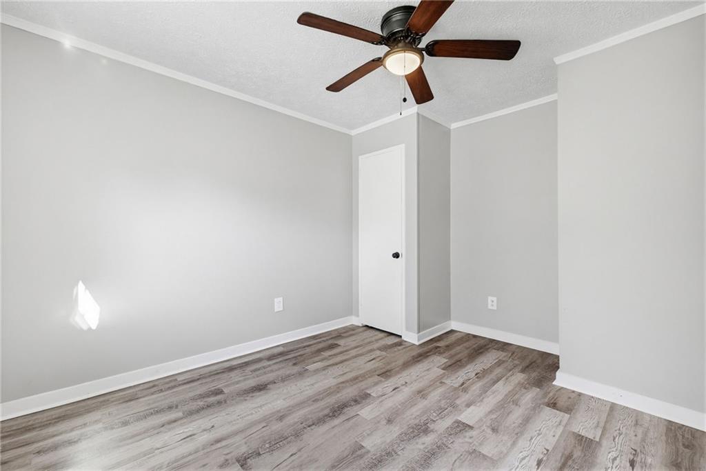 1789 Cahoon Street Southwest Atlanta, GA 30310 - Photo 14 of 15 an empty room with wooden floor and a ceiling fan