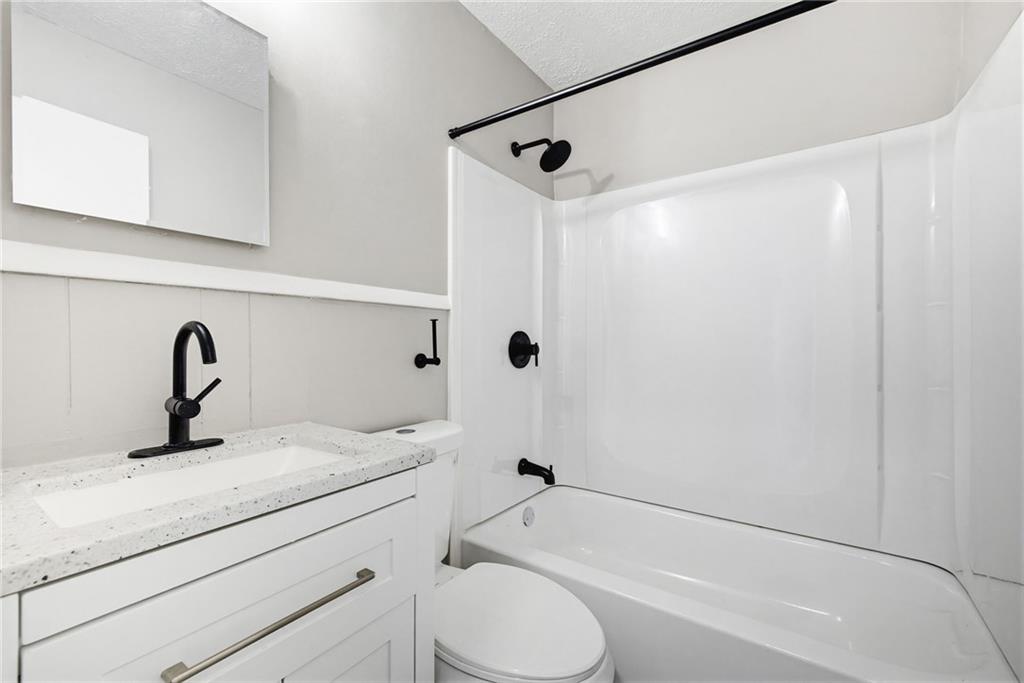 1789 Cahoon Street Southwest Atlanta, GA 30310 - Photo 16 of 16 a bathroom with a granite countertop sink toilet and shower