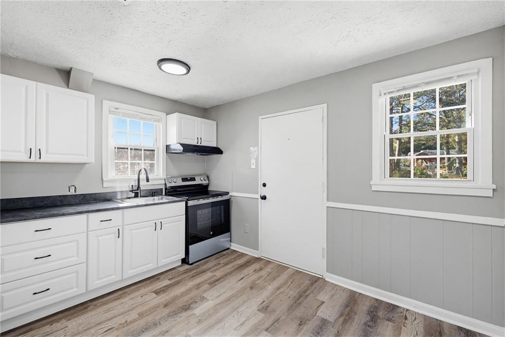 1789 Cahoon Street Southwest Atlanta, GA 30310 - Photo 4 of 16 a kitchen with granite countertop white cabinets and white appliances