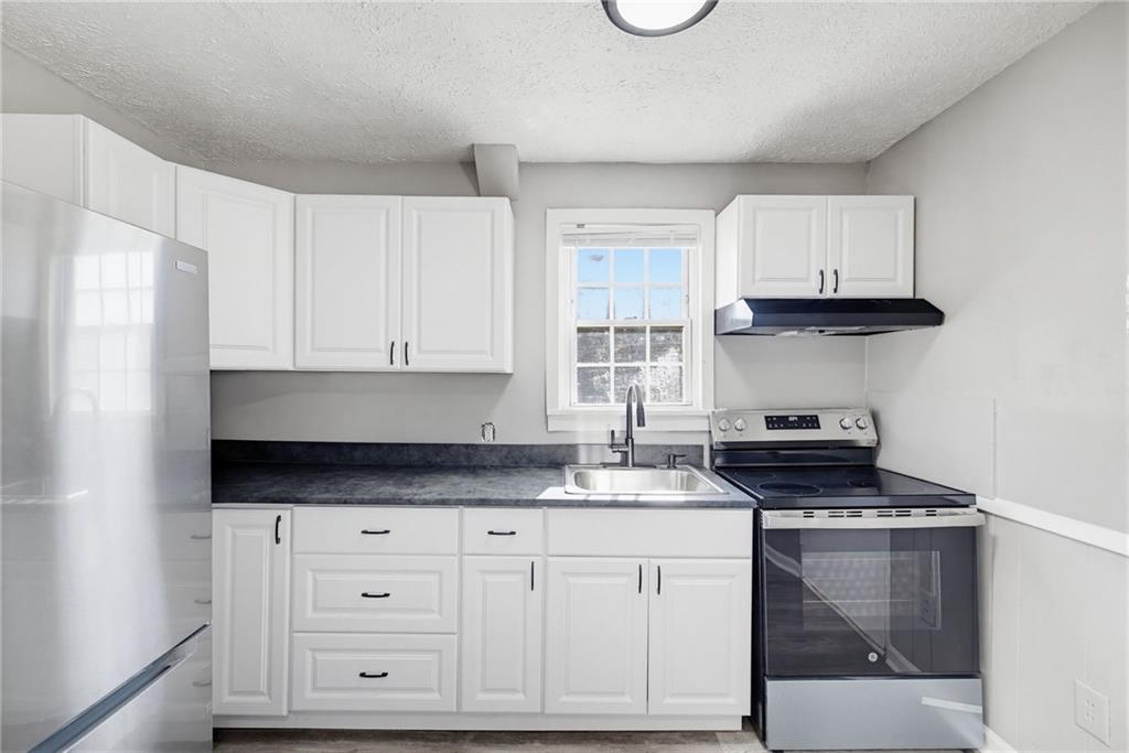 1789 Cahoon Street Southwest Atlanta, GA 30310 - Photo 5 of 16 a kitchen with granite countertop a stove a sink and a microwave