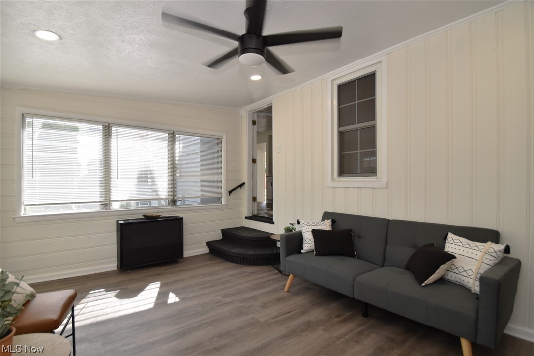 1259 Churchill Road Cleveland, OH 44124 - Photo 11 of 24 Living room featuring radiator heating unit, ornamental molding, light hardwood floors, and vaulted ceiling