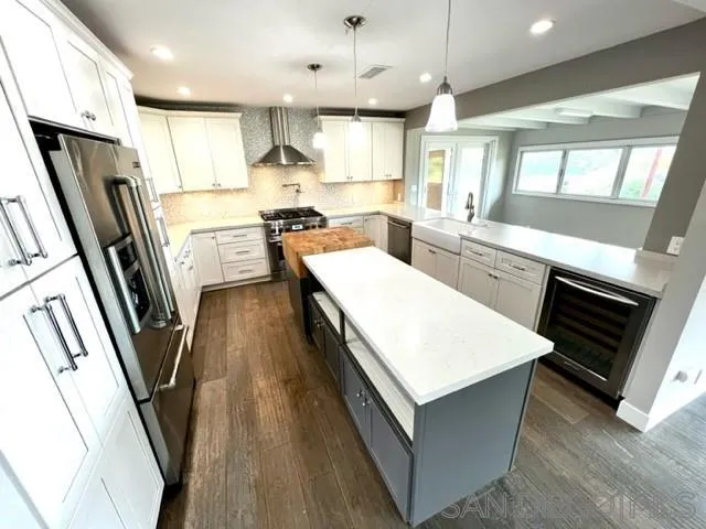 13822 Northcrest Lane Poway, CA 92064 - Photo 5 of 26 a kitchen with a sink a refrigerator a oven a stove and a dining table with wooden floor