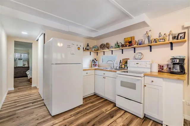a kitchen with cabinets and wooden floor