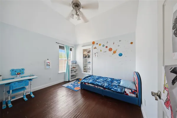 a bedroom with a bed and wooden floor
