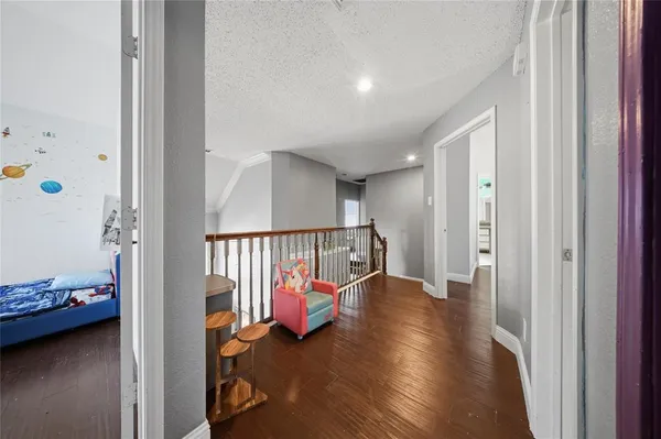 a view of a hallway with wooden floor and stairs