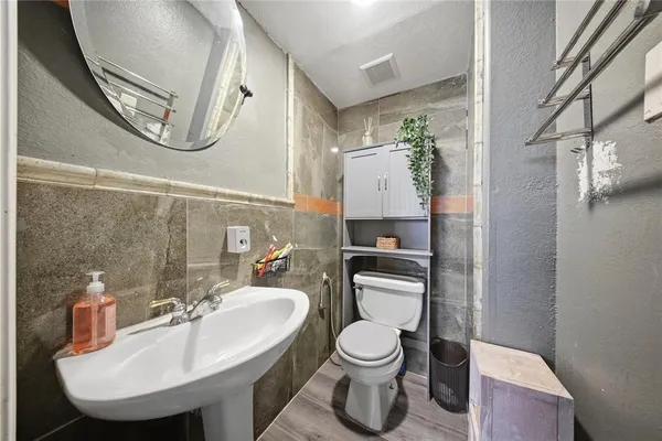 a bathroom with a toilet sink and mirror