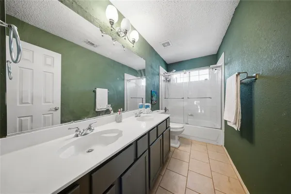 a bathroom with a double vanity sink mirror and shower