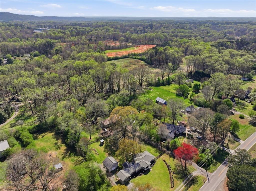 2215 Roper Road Cumming, GA 30028 - Photo 24 of 24 an aerial view of green landscape with trees houses and mountain view