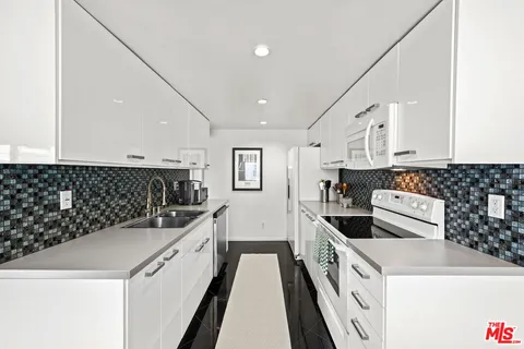 a kitchen with granite countertop a sink and a stove