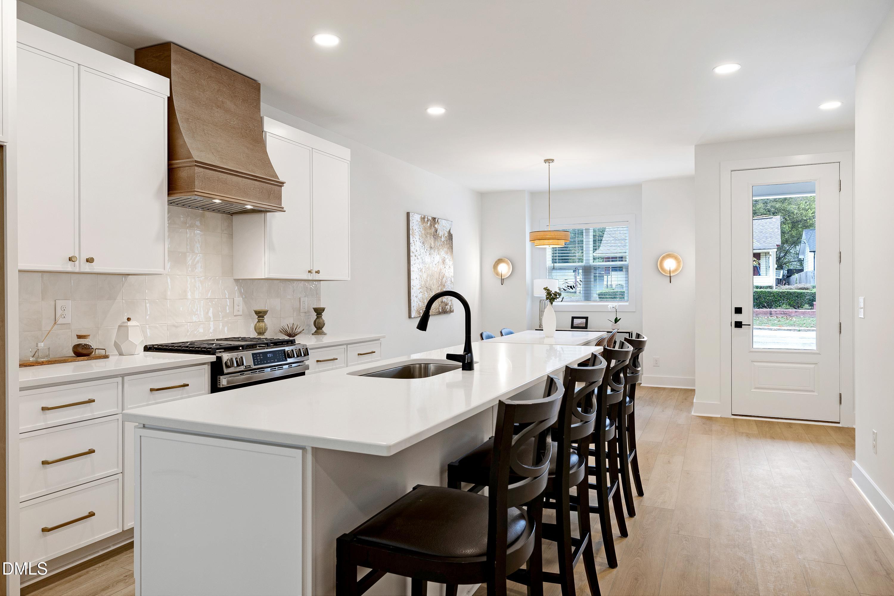 1418 Joe Louis Avenue Raleigh, NC 27610 - Photo 16 of 49 a kitchen with stainless steel appliances a table chairs and a stove top oven