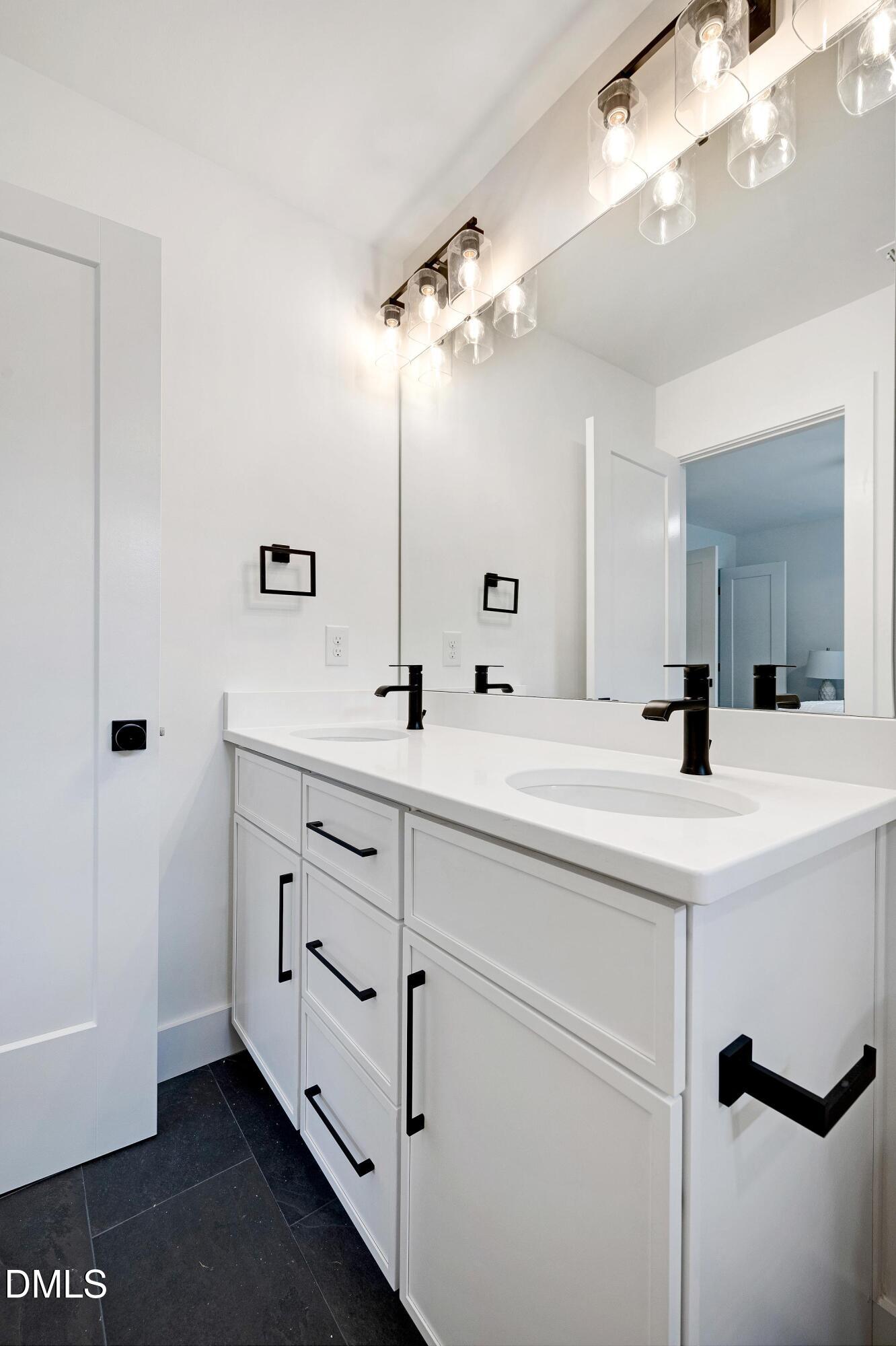 1418 Joe Louis Avenue Raleigh, NC 27610 - Photo 27 of 49 a bathroom with a double vanity sink a mirror and shower
